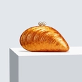 Detail of amber acrylic shell bag with pearl clasp on a minimalist display stand - Orange