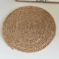Handwoven round straw placemat in natural beige with a detailed braided texture finish - Round 30cm