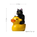 Miniature figurine featuring a black kitten riding a yellow duck for garden decor - Black Cat Riding Duck