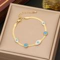 Goldenes Schlangenarmband mit blauem Auge-Element auf einer Schmuckschatulle - 2# Armband