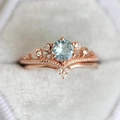 Rose gold crown ring set with round blue zircon and v-shaped band on velvet - US 6 / Rose Gold