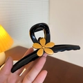 Black monster hair claw clip with golden flower detail held in hand for hair styling - 34# Claw Clip