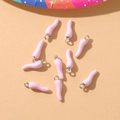 Close-up of ten pink chili pepper resin pendants with silver metal loops for DIY jewelry - Pink