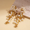 Macro detail of gold tassel earrings featuring white pearls and rhinestone spheres - Gold / Gold