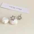 Detailed view of silver hexagonal star earrings with zircon inlay on white pebble - Rhodium Plated Silver Star Zirconia Studs
