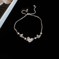 Adjustable silver bracelet featuring zircon heart charm with LOVE engraving on dark surface - Silver Heart