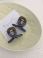 Detail shot of two smoke grey resin hair claws with minimalist twist design and gold springs - Mini Butterfly Clip X-Shaped (Approx. 4cm) / Light Silver Grey