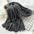 Grey crinkled scarf with tassels draped on a mesh rack and woven basket for winter - Ink Gray