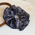 Detailansicht eines dunkelblauen Haargummis mit Paisleymuster auf einem Holztablett - Haargummi mit Spitzenkante / Blau