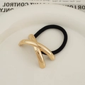 Minimalist elastic hair tie with polished gold metal X-shape charm on a white ceramic plate - Glossy X-Shape Gold