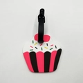 Close-up of a pink cupcake silicone luggage tag with colorful sprinkles and black strap - Cake