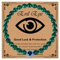 Macro detail of 6mm green malachite bead bracelet with blue evil eye on display card - Malachite Bracelet