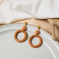 Geometric wooden hoop earrings with gold metal studs shown on a white silk background - E1689-4 (Orange Brown Ring)