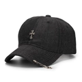Dettaglio del cappello in denim nero con croce in metallo argento e spilla punk laterale - Nero