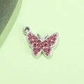 Ciondolo a farfalla d'argento con cristalli rosa e anello di aggancio su sfondo verde - Farfalla Rosa Placcata Argento UV