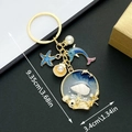 Golden ocean keychain with blue starfish, dolphin pendants and a round seashell resin charm - Enamel Blue Dolphin Starfish Shell Pearl Style