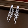 Macro view of long silver tassel earrings featuring marquise-cut crystal rhinestones - Silver-Transparent