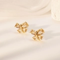 Vista macro di orecchini a farfalla dorati con zirconi brillanti su base minimalista - Champagne