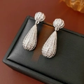 Vue macro de boucles d'oreilles goutte argentées avec cristaux sur écrin noir - Plaqué Or Véritable Tige en Argent Argent / Argenté