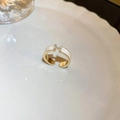 Close-up of golden H-shaped ring with white enamel and sparkling zircon diamonds - Gold H Alphabet Enamel Zirconia Style