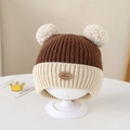 Detalle del gorro de punto con dos pompones crema y una etiqueta redonda de cuero - 1-3 Años / Marrón