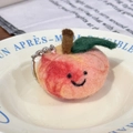 Handmade pink wool felt peach keychain with a cute smiley face and green leaf detail - Longevity Peach