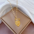 Golden lion head necklace with crown and colorful gems on beige jewelry box - Lion Head with Crown Style (E522)