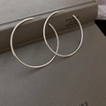 Dettaglio macro di grandi orecchini a cerchio in argento a forma di C su un libro - Extra Grande-6cm (Perno S925)