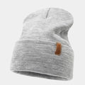 Dettaglio della trama del berretto in maglia grigio chiaro e toppa in pelle marrone - Grigio Melange Chiaro