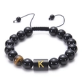 Adjustable black onyx bead bracelet featuring a tiger eye stone and golden letter K charm - Letter K