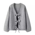 Detailaufnahme der grauen Strickjacke mit silbernen Pailletten-Schleifenverschlüssen - S / Grau
