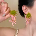 Detail of handmade beaded flower tassel earrings with pink and green beads worn on ear - Soft Green and Pale Pink Handmade Beaded Tassel Earrings