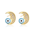 Macro detail of gold-plated moon and evil eye stud earrings with cubic zirconia and blue enamel - Moon Blue Evil Eye