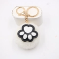 Detail van witte pluche bal sleutelhanger met kattenpootje en gouden sluiting - Kattenklauw Goud Sleutelhanger / Off-wit