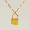 Collier avec pendentif cadenas doré et gravure de lettre sur fond beige neutre - Style Lettre W