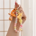Detail van kleurrijke DIY sleutelhanger met oranje speen, gele beer en kralen - Licht Gouden Gesp + Ketting + Speen + Fles / Citroengeel