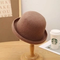 Detail of dark brown wool felt bowler hat with rolled brim on a wooden stand - M (56-58cm) / Camel