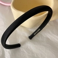Close-up of black satin padded headband featuring a gold-stamped HAND MADE label inside - Black
