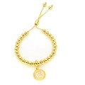 Bracelet à perles dorées réglable avec un pendentif lettre E sur fond rose - Lettre E