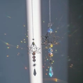 Lotus suncatcher with metal frame and crystal beads casting rainbow light on the wall - Silver Lotus