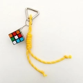 Close-up of a colorful 3x3 magic cube pendant with a yellow braided rope and silver carabiner - Yellow Rope + Magic Cube