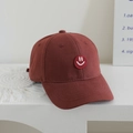 Close-up of burgundy kids baseball cap with a red embroidered smiley face patch - Kids One Size / Orange Khaki