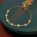 Close-up of gold flower bracelet with cubic zirconia and adjustable slider clasp - Gold