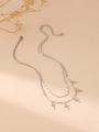 Detailed view of silver double-layered necklace with five small cross pendants on sand background - Cross / Silver