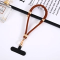 Detail of adjustable brown nylon phone lanyard with gold metal clips and black patch - Coffee
