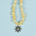 Irregular yellow crystal stone necklace with a silver sun pendant on blue background - Citrine Sun