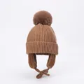 Detailed view of brown winter knit hat with fluffy pom pom and warm fleece lining - S / Coffee
