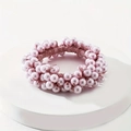 Close-up of handmade pink faux pearl elastic hair tie on a white podium surface - Pink