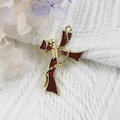 Golden alloy cross pendant with red enamel inlay on a soft knit background - 12-Gold Red Skull Cross