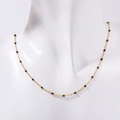 Bohemian gold chain necklace with black bead accents displayed on a white mannequin - Black